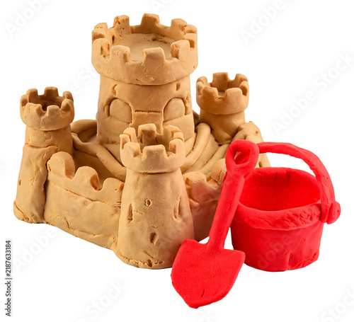 Handmade clay sandcastle with red bucket and shovel on white background