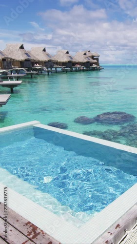 Resort hotel Infinity pool in travel vacation paradise with overwater bungalow in ocean lagoon with coral reef sea. 4K Video from Bora Bora, French Polynesia, Tahiti, South Pacific Ocean. Real video.