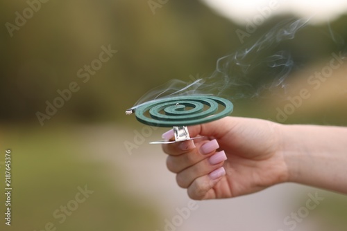 Фотография Woman with insect repellent coil outdoors, closeup