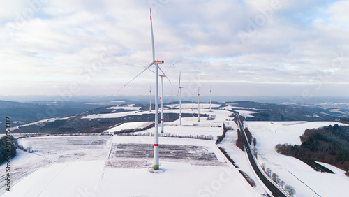 Foto Windless wind turbine in snow, dark doldrums or wind lull in winter, renewable s