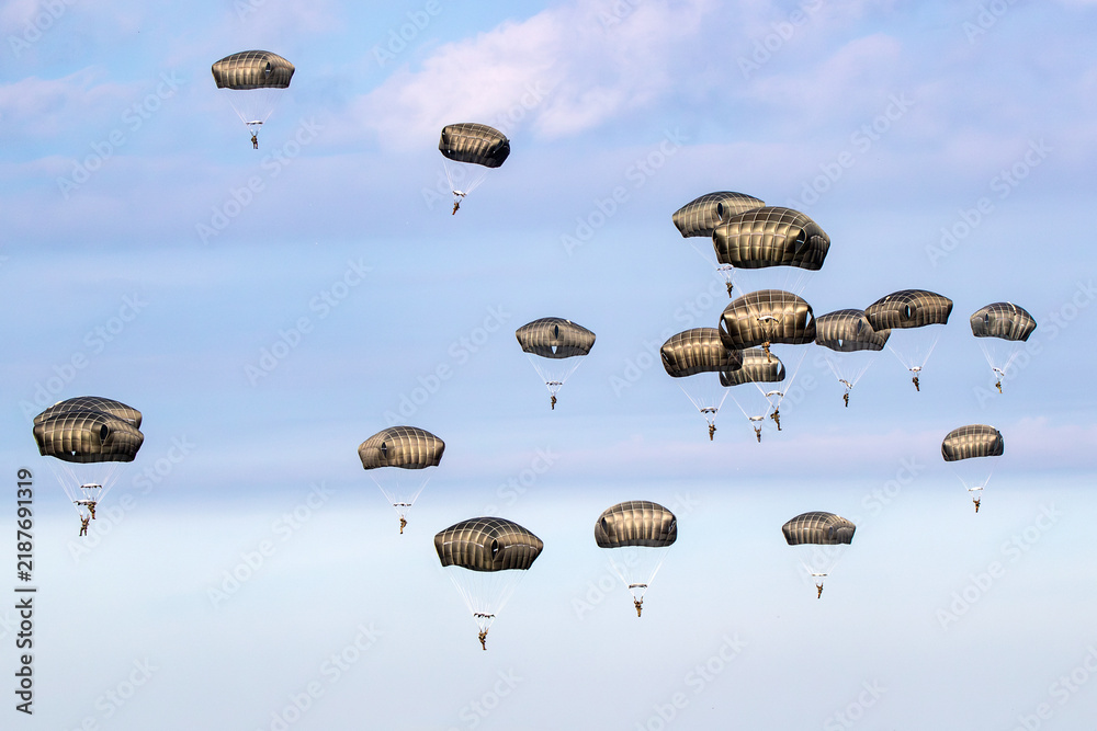 Obraz premium Military parachutist paratroopers parachute jumping out of an air force plane.