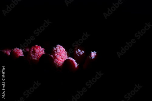 Frozen raspberries on dark background