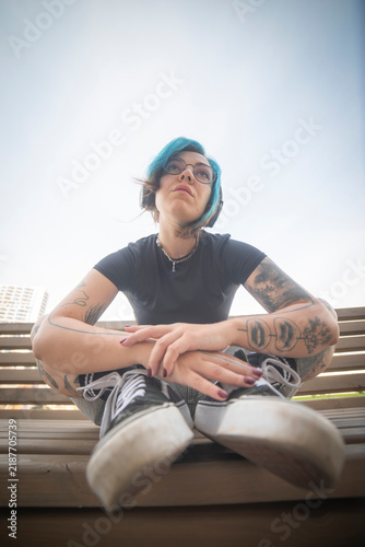 Canvastavla Pensive gen z alternative woman with blue hair sitting on bench with copy space