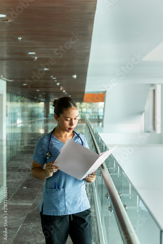 Healthcare professional reading medical records in modern hospital