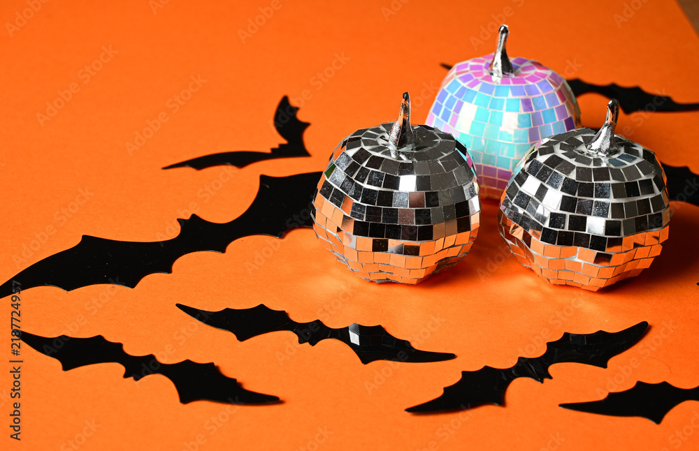 Fototapeta premium halloween party decoration with black paper bats and shiny disco ball ornaments on orange background