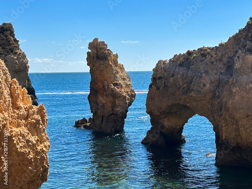 Beautiful view of picturesque golden sandstone cliffs and arches on a summer day. Lagos. Algarve region. Portugal.