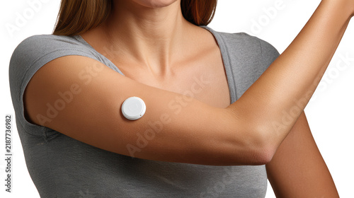 Woman wearing a continuous glucose monitor on her upper arm