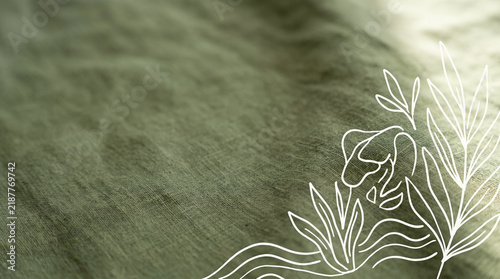 Green linen textile surface with white botanical line art, creating calm natural background for elegant design projects