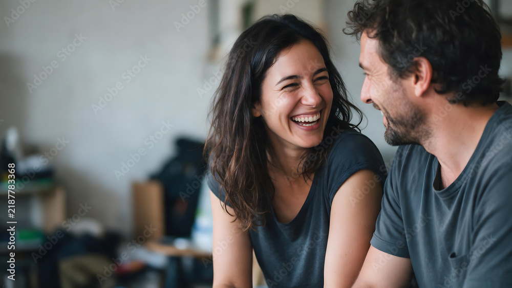 Fototapeta premium Couple laughing together in a relaxed home setting