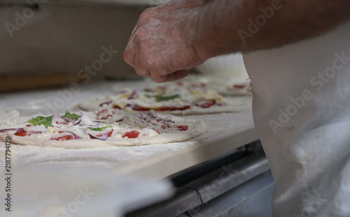 Quadro su tela pizzaiolo prepara le pizze sul bancone di una pizzeria