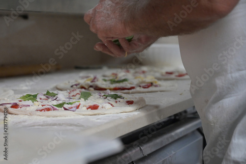 Quadro su tela pizzaiolo prepara le pizze sul bancone di una pizzeria