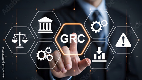 Governance risk and compliance concept with businessman touching virtual interface screen. Digital workflow featuring scales of justice, courthouse, gears, and warning symbols for enterprise risk 