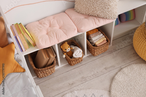 Home organization and nursery storage  tidy children room with wicker baskets and books on white shelving unit for interior design and lifestyle
