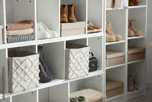 Shelf unit with winter shoes and clothes in dressing room