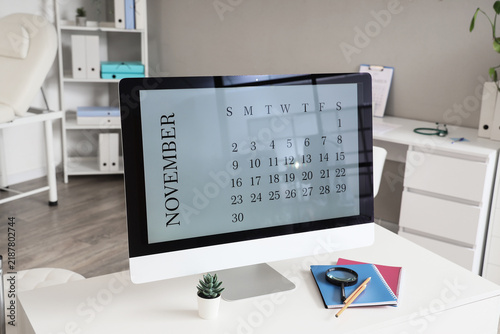 Doctors workplace with computer monitor with calendar on screen in office