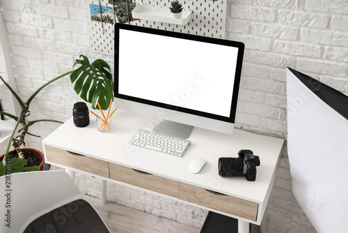 Photographers workplace with blank computer monitor in office