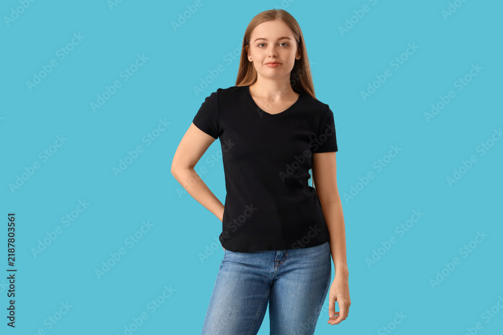 Fototapeta premium Young woman in stylish black t-shirt on blue background