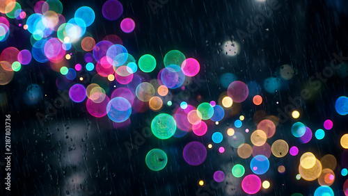 Abstract background of colorful glowing rain bokeh lights on a dark window