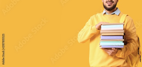 Education and academic success, smiling student holding a stack of books for ...