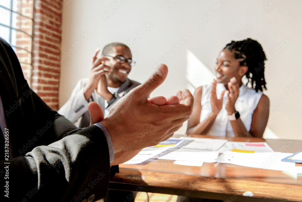 Obraz premium People clapping in a bright office setting, celebrating success.
