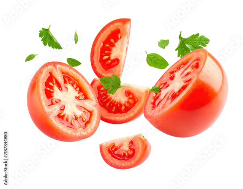 Fresh Tomato Slices and Green Herb Leaves Flying in Midair Isolated on White