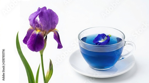 Purple iris flower beside a clear glass cup filled with blue butterfly pea flower tea on a white saucer butterfly beverage infusion relaxing refreshment background isolated transparent