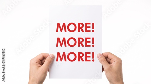 Hands holding white paper with red more text repeated