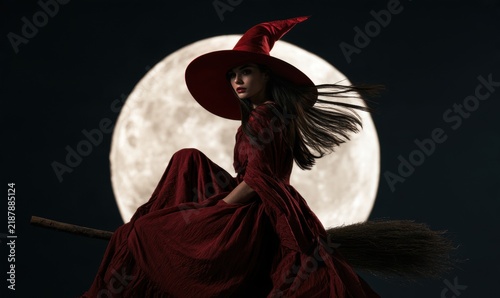 Witch on a broomstick flying before a full moon