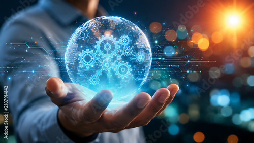 Hand holding glowing globe with mechanical gears representing global engineering industry and technological innovation connectivity.