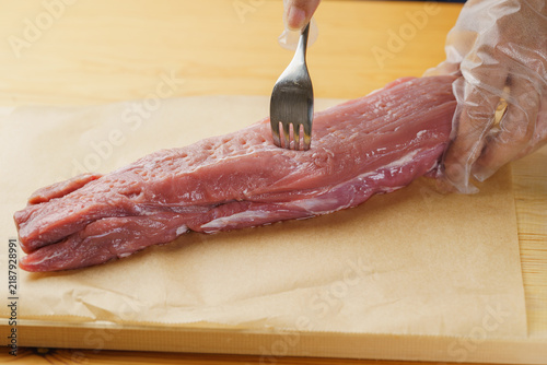 Fototapeta 肉の下ごしらえ│豚ヒレ肉の塊にフォークを刺す・穴あけ