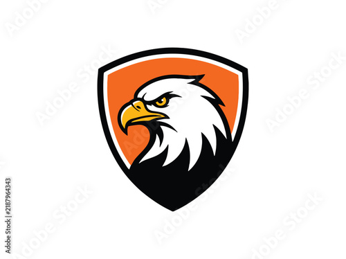 Bald eagle mascot logo on orange shield. Fierce bird of prey head vector. Sport team emblem with majestic eagle profile.