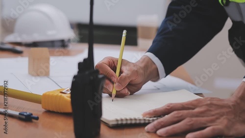 Close-up Of Person's engineer Hand Drawing Plan On Blue Print with architect equipment, Architects discussing at the table, team work and work flow construction concept
