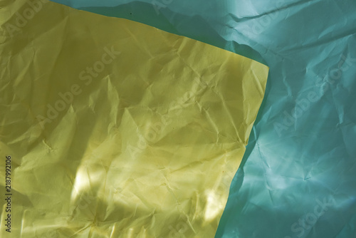Foto Abstract two-tone crumpled paper texture in vibrant yellow and teal, ideal background for creative craft, modern packaging, and minimalist summer design projects