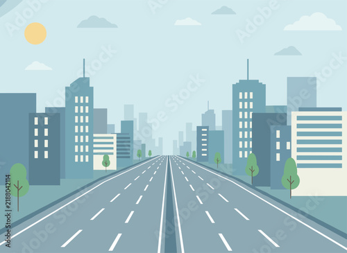 Empty multi lane highway stretching into the distance towards high rise skyscrapers under sunny blue sky.