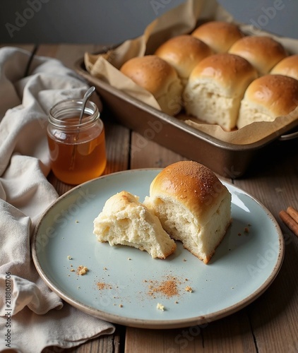 Freshly baked soft dinner rolls served with honey and cinnamon