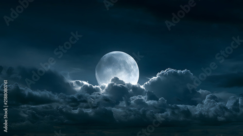 Full moon illuminating dark cloudy night sky landscape