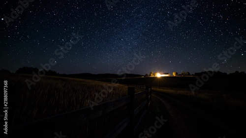 Wooden fence path under the starry sky in the fields at night, countryside under the starry sky