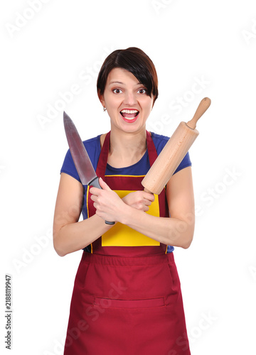 Woman wearing apron holding knife and rolling pin.