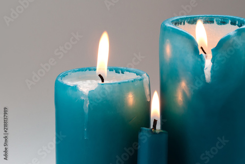Turquoise candles in three sizes with burning flames. Aromatherapy concept, wellness flyer, meditation leaflet