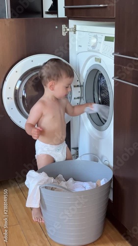 Toddler loading laundry into washing machine