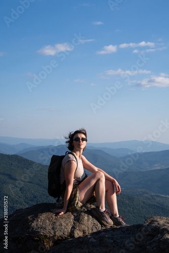 woman sitting on top of a mountain on rocks