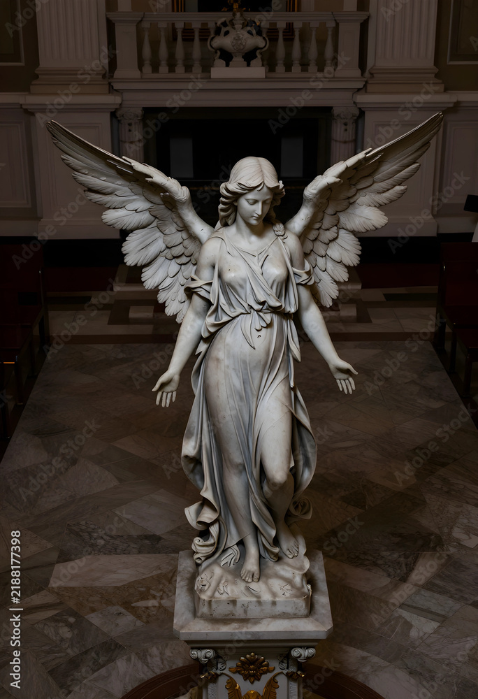 Fototapeta premium Spirituality and religion concept marble angel statue with wings spread in a church interior for funeral memorial and peace themes in architecture