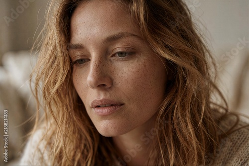 Freckled Blonde Woman with Wavy Hair Looking Down