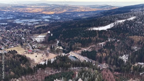 Aerial Village Beside Winding Reservoir, Houses, Roads, Dam, Forested Slopes, Rural Community, Calm Winter