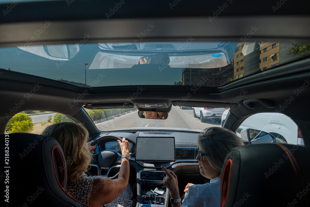 Obraz premium Women driving modern car with sunroof on city trip