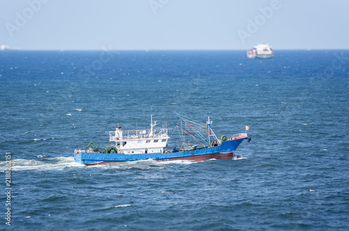 Картината върху платно Traditional Chinese fishing vessel underway in coastal waters under bright sunshine, highlighting small-scale fishing, maritime transportation and life at sea
