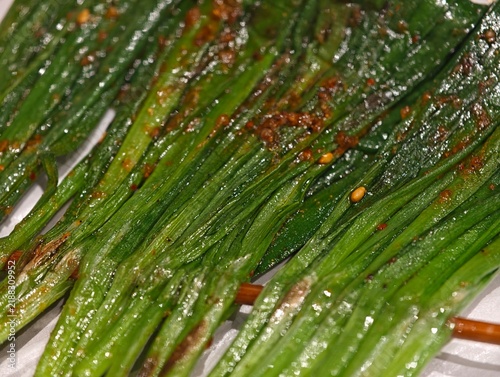 close-up Chinese grilled chives on a skewer, seasoned with chili powder, cumin, and spices.