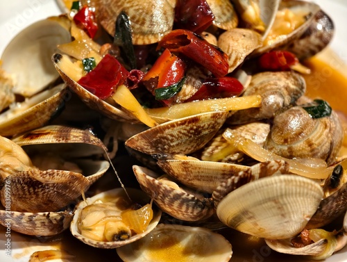 freshly cooked Chinese stir-fried clams dish, featuring clam shells, red chili peppers and savory sauce