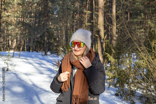 Cuadro en lienzo Middle aged woman wears ski goggles and angora winter hat while standing in snowy pine forest