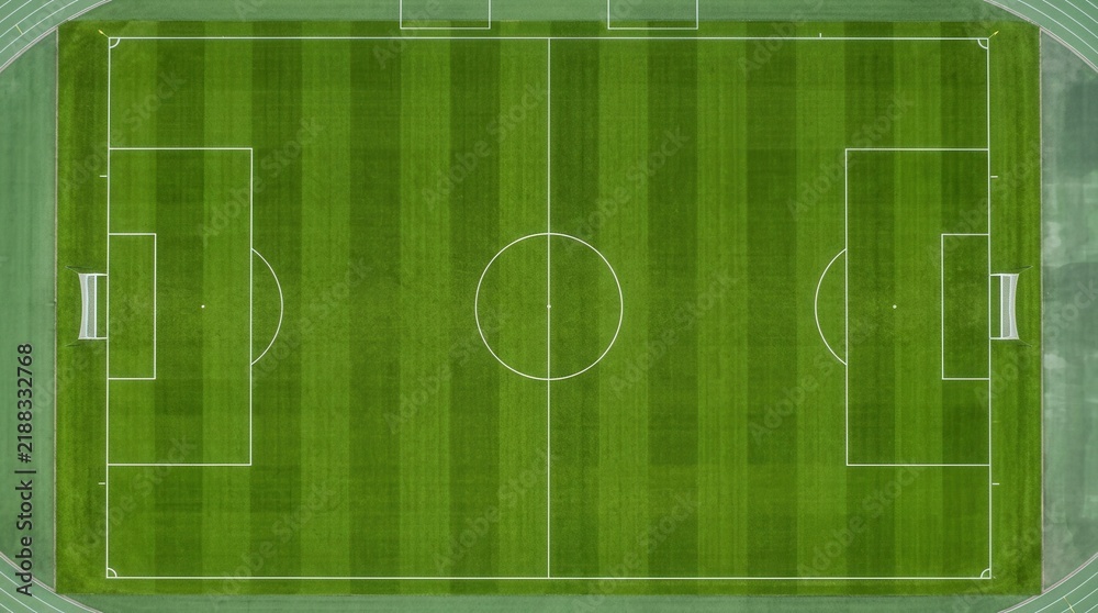 Obraz premium Lush green grass texture and marked lines on a soccer field aerial view